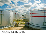 Нефтяные цистерны на фоне облачного неба. Стоковое фото, фотограф Павел Просянов / Фотобанк Лори