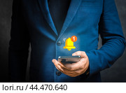 Push notification. Businessman holding smartphone with virtual yellow bell ringing for application notification alert concept. Стоковое фото, фотограф Павел Муравьев / Фотобанк Лори