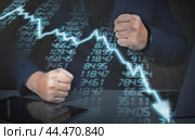 Furious businessman clenching his fists looking at graph of declining profit. Businessman Looking Up At Chart That Indicates Falling Dollar. Graphs representing stock market crash caused. Стоковое фото, фотограф Павел Муравьев / Фотобанк Лори
