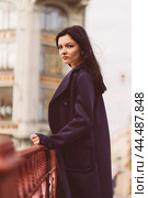 Portrait close-up of beautiful intelligent brunette who walks down street of St. Petersburg in city center. Charming thoughtful woman with long dark hair wanders alone, immersed in thoughts. Стоковое фото, фотограф Natalia Gdovskaia / Фотобанк Лори