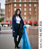 Charming thoughtful fashionably dressed woman with long dark hair travels through Europe, standing in city center of St. Petersburg. A beautiful girl wanders alone through autumn streets. Стоковое фото, фотограф Natalia Gdovskaia / Фотобанк Лори