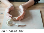 Woman making pottery, hands closeup, blurred background, focus on potters, palms with pottery. Turning passion into a job. Стоковое фото, фотограф Natalia Gdovskaia / Фотобанк Лори