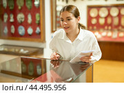 Woman looking at exhibits in glazed stands in museum. Стоковое фото, фотограф Яков Филимонов / Фотобанк Лори