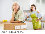 Quarrel of an elderly mother and adult daughter in the kitchen. Adult daughter is unhappy with elderly mother. Стоковое фото, фотограф Яков Филимонов / Фотобанк Лори