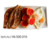 Fried eggs with pancetta slices and pan con tomate sandwiches. Стоковое фото, фотограф Яков Филимонов / Фотобанк Лори