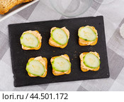 Simple homemade snack of sandwiches, greased with butter and decorated with slice of cucumber. Стоковое фото, фотограф Яков Филимонов / Фотобанк Лори