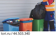 Waste collection worker sorts trash at local facility in vibrant recycling bins during mid-afternoon shift. Стоковое видео, видеограф Сергей Толмачёв / Фотобанк Лори