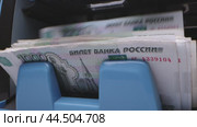 Counting Russian banknotes from an ATM in a busy urban location during daytime operations. Стоковое видео, видеограф Сергей Толмачёв / Фотобанк Лори