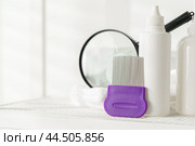 Lice treatment product next to a nit comb and magnifying glass. Стоковое фото, фотограф Сергей Толмачёв / Фотобанк Лори