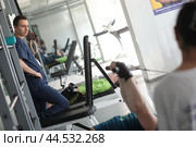 Инструктор центра доктора Бубновского помогает делать упражнение пациенту (2024 год). Редакционное фото, фотограф Дмитрий Неумоин / Фотобанк Лори