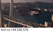 Automobile traffic on the Golden Bridge in Vladivostok, with hills and a bay in the background. Автомобильное движение по Золотому мосту во Владивостоке на фоне сопок и бухты. Стоковое видео, видеограф Валерий Тесаков / Фотобанк Лори