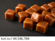 Closeup of soft caramel candy on dark background. Стоковое AI-изображение, AI-художник Иван Рябоконь / Фотобанк Лори