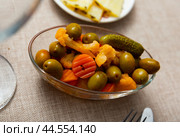 Light snack - oval bowl with pickled vegetables, gherkin and green olives. Стоковое фото, фотограф Яков Филимонов / Фотобанк Лори