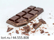 Dark chocolate bar with shavings on white. Стоковое AI-изображение, AI-художник Иван Рябоконь / Фотобанк Лори
