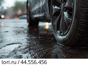 Rainsoaked street with car tire closeup. Стоковое AI-изображение, AI-художник Иван Рябоконь / Фотобанк Лори