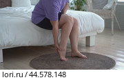 The woman's calf muscle cramped, massage of female leg at home. Стоковое видео, видеограф Станислав Тарко / Фотобанк Лори