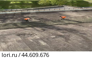 IRKUTSK, RUSSIA - September 06, 2024: Vertical video of road workers in orange vests leveling sand and gravel mixture with shovels for the road surface. View from above. Редакционное видео, видеограф Виктория Катьянова / Фотобанк Лори