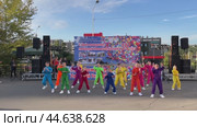 IRKUTSK, RUSSIA - September 06, 2024: Video of an annual celebration in University district. A group of schoolgirls in brightly colorful costumes dance funny sport dance on open stage on sunny September day. Редакционное видео, видеограф Виктория Катьянова / Фотобанк Лори