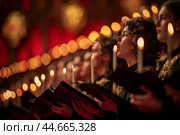 Choral performance in a historical venue with candlelight enhancing the atmosphere during winter festivities. Стоковое AI-изображение, AI-художник Сергей Толмачёв / Фотобанк Лори
