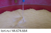 Adding Water To Dough In A Red tumbling machine for polishing coins blanks. Стоковое видео, видеограф Гурьянов Андрей / Фотобанк Лори