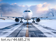 Passenger airplane standing on runway covered with snow. Стоковое AI-изображение, AI-художник Иван Рябоконь / Фотобанк Лори