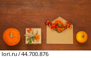 Pumpkins, marigolds, handmade gifts on old wooden background. Beautiful blank for congratulations on autumn holiday, on Thanksgiving, on Halloween or beginning of autumn. Flat lay, copy space, mock up. Стоковое фото, фотограф Виктория Катьянова / Фотобанк Лори
