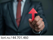 Businessman holding red up arrow representing growth and success. Стоковое AI-изображение, AI-художник Иван Рябоконь / Фотобанк Лори