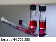 Scientist analyzing red liquid in flasks with pipettes in a laboratory. Стоковое AI-изображение, AI-художник Иван Рябоконь / Фотобанк Лори