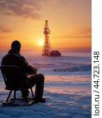 Oil worker resting after shift, near oil and gas drilling rig. Winter sunset. Стоковое AI-изображение, AI-художник Сергей Елизарьев / Фотобанк Лори
