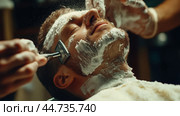 A classic barber shaving experience with rich lather in a vintage barbershop setting during the daytime. Стоковое AI-изображение, AI-художник Сергей Толмачёв / Фотобанк Лори