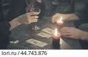 People enjoying a candlelit evening while gambling with playing cards and a glass of drink on a rustic table. Стоковое AI-изображение, AI-художник Сергей Толмачёв / Фотобанк Лори