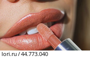 Woman applying pink lip gloss with glitter on her lips. Стоковое AI-видео, аниматор Юрий Поздников / Фотобанк Лори