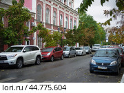 Астрахань. Вдоль главной улицы города припаркованные автомобили. По центру - дом, памятник архитектуры, который впоследствии сильно пострадает от пожара. В этом доме с 90-х годов 19 века  жил и работал известный астраханский архитектор, Сергей Иванович Карягин. (2017 год). Редакционное фото, фотограф Павел Просянов / Фотобанк Лори