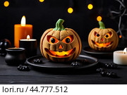 Pumpkin cookies with evil face and eyes on black wooden table with candles. Стоковое AI-изображение, AI-художник Васильева Юлия / Фотобанк Лори
