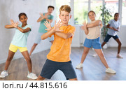 Smiling preteen boy practicing vigorous dance with group in studio. Стоковое фото, фотограф Яков Филимонов / Фотобанк Лори