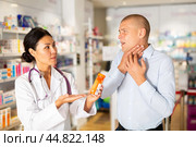 Man complaining to female druggist about sore throat. Стоковое фото, фотограф Яков Филимонов / Фотобанк Лори