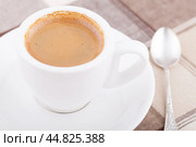 Кофейный натюрморт: белая чашка с кофе, мельхиоровая ложка на клетчатой скатерти. Стоковое фото, фотограф Александр Рыбалка / Фотобанк Лори