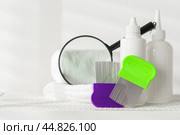 Lice treatment product next to a nit comb and magnifying glass. Стоковое фото, фотограф Сергей Толмачёв / Фотобанк Лори