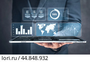 Businessman with digital tablet and ESG. virtual interface shows the benefits of investing in esg business. ESG environmental social governance business strategy investing concept. Стоковое фото, фотограф Павел Муравьев / Фотобанк Лори
