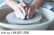 A man dries a white clay product with a hair dryer on a potter's wheel. Craft, creativity, the process of working on a potter's wheel. Стоковое видео, видеограф Терехова Марина / Фотобанк Лори