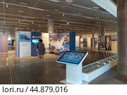 Люди читают информацию на выставке «Россия — страна морей и океанов». Музей военно-морской славы. Музейно-исторический парк «Кронштадт. Остров фортов». Санкт-Петербург (2024 год). Редакционное фото, фотограф Румянцева Наталия / Фотобанк Лори