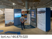 Человек читает информацию, связанную с Каспийским морем. Выставка «Россия — страна морей и океанов». Музей военно-морской славы. Музейно-исторический парк «Кронштадт. Остров фортов». Санкт-Петербург (2024 год). Редакционное фото, фотограф Румянцева Наталия / Фотобанк Лори