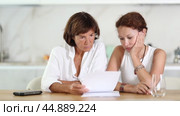Two adult women discuss documents, try to solve financial problems. Стоковое видео, видеограф Яков Филимонов / Фотобанк Лори