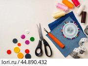 Sewing supplies and denim fabric arranged on a workspace for clothing alterations in a bright setting. Стоковое фото, фотограф Сергей Толмачёв / Фотобанк Лори