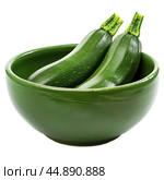 Two fresh green zucchinis resting in a green bowl. Стоковое AI-изображение, AI-художник Иван Рябоконь / Фотобанк Лори