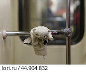 White toy kitten on the handrail in the subway. Стоковое фото, фотограф YuryKara / Фотобанк Лори