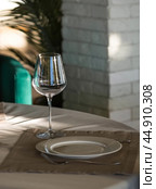 Stylish table setting. Glass glasses, plates, cutlery on the table. Wedding service, reception at the dining table. A birthday, a baptism, a festive event. Стоковое фото, фотограф Photojuli / Фотобанк Лори
