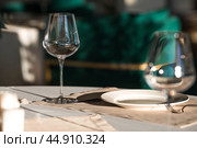 Stylish table setting. Glass glasses, plates, cutlery on the table. Wedding service, reception at the dining table. A birthday, a baptism, a festive event. Стоковое фото, фотограф Photojuli / Фотобанк Лори
