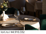 Stylish table setting. Glass glasses, plates, cutlery on the table. Wedding service, reception at the dining table. A birthday, a baptism, a festive event. Стоковое фото, фотограф Photojuli / Фотобанк Лори