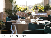 Stylish table setting. Glass glasses, plates, cutlery on the table. Wedding service, reception at the dining table. A birthday, a baptism, a festive event. Стоковое фото, фотограф Photojuli / Фотобанк Лори